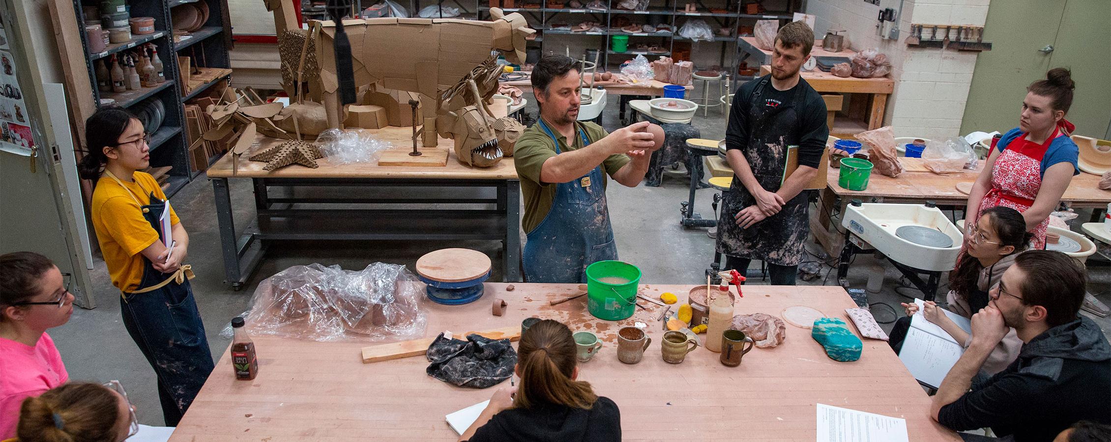 Art and design student learns about sculpting with a professor at the University of Wisconsin Whitewater.