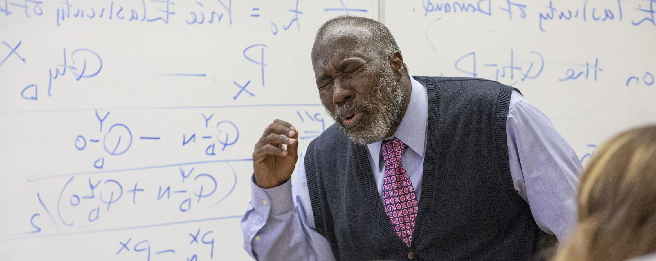 A faculty member speaks at the front of class.